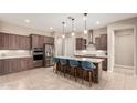 Modern kitchen with a large island, stainless steel appliances, and pendant lighting at 26161 W Siesta Ln, Buckeye, AZ 85396