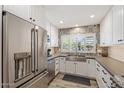 Well-lit kitchen with white cabinets, stainless steel refrigerator, and patterned backsplash at 2727 W Ocaso Cir, Mesa, AZ 85202