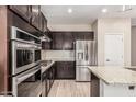 Gourmet kitchen featuring stainless appliances, gas cooktop, tiled backsplash and granite countertops at 28263 N Welton Pl, San Tan Valley, AZ 85143