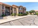 Two-story condo building featuring desert landscaping, a red tile roof, and convenient parking at 5230 E Brown Rd # 114, Mesa, AZ 85205