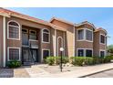 Two-story condo building with desert landscaping, a red tile roof, and private entry stairs at 5230 E Brown Rd # 114, Mesa, AZ 85205