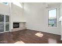 Bright living room featuring hardwood floors, a fireplace, and large windows that provide plenty of natural light at 6510 S Hazelton Ln # 101, Tempe, AZ 85283