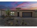 Charming single-story home with a well-maintained front yard and a two-car garage against a colorful sky at 699 E Watermelon Ln, Queen Creek, AZ 85140