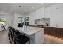 Bright, modern kitchen with large center island, sleek white cabinets, and stainless steel appliances at 7152 E Night Glow Cir, Scottsdale, AZ 85266