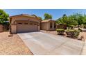 Spacious driveway leading to a two-car garage, complemented by desert landscaping and a well-maintained exterior at 7169 W Lamar Rd, Glendale, AZ 85303
