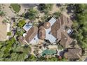 An aerial view of a luxury estate with a tile roof, a private pool, and lush landscaping at 7640 E Poinsettia Dr, Scottsdale, AZ 85260