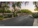 A secure, gated entrance with mature trees and manicured landscaping provides privacy and curb appeal at 7640 E Poinsettia Dr, Scottsdale, AZ 85260