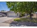 Inviting front exterior featuring a well-manicured lawn, shade tree, and convenient two-car garage at 807 E San Remo Ave, Gilbert, AZ 85234