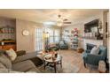 Cozy living room featuring a decorative ceiling fan, a fireplace, and built-in bookshelves at 8787 E Mountain View Rd # 1110, Scottsdale, AZ 85258