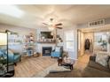 Bright living room featuring wood flooring, neutral paint, fireplace and a decorative ceiling fan at 8787 E Mountain View Rd # 1110, Scottsdale, AZ 85258