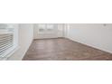 An empty bedroom offers views from windows and features wood-look floors at 9507 S Mara Dr, Apache Junction, AZ 85120