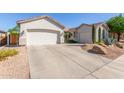 This home features a long driveway leading to a spacious two-car garage with desert landscaping at 9623 S 25Th Ln, Phoenix, AZ 85041