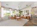 Bright living room boasts large windows, comfortable seating, neutral decor, and an adjacent kitchen at 9623 S 25Th Ln, Phoenix, AZ 85041