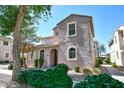 Attractive two-story home with manicured shrubs and a tree set against a clear blue sky at 10136 E Isleta Ave, Mesa, AZ 85209
