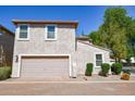 A beige colored detached garage, complemented by a brick driveway and tidy landscaping at 10136 E Isleta Ave, Mesa, AZ 85209