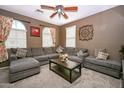 Cozy living room features a plush sectional sofa, ceiling fan, and window treatments for a comfortable ambiance at 10136 E Isleta Ave, Mesa, AZ 85209