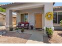 Inviting front porch featuring a cozy bench, potted plants, and a decorative wreath at 10235 E Jerome Ave, Mesa, AZ 85209