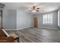 Bright living room featuring plank flooring, a wooden door and a ceiling fan at 10235 E Jerome Ave, Mesa, AZ 85209
