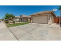 Charming single-Gathering home featuring a two-car garage, manicured lawn, and inviting curb appeal on a sunny day at 11206 W Coronado Rd, Avondale, AZ 85392