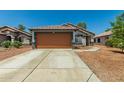 Inviting single-Gathering home featuring a spacious driveway and low-maintenance desert landscaping at 14936 W Maui Ln, Surprise, AZ 85379