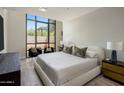 Serene bedroom featuring a large window, comfortable seating, and a plush bed with stylish pillows at 15215 N Kierland Blvd # 101, Scottsdale, AZ 85254