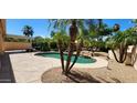 Relaxing backyard oasis with a pool, surrounded by lush landscaping and palm trees at 15728 W Verde Ln, Goodyear, AZ 85395