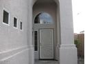 Elegant front door under arched entryway, with decorative security door and sidelight window at 16029 W Ocotillo Ln, Surprise, AZ 85374