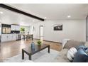 Bright and airy living room showcasing hardwood floors, white walls, and a seamless connection to the kitchen at 16523 N Queen Esther Dr, Surprise, AZ 85378