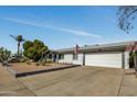 A single-story white brick home is set back from the street with desert landscaping and a long driveway at 18035 N 29Th Dr, Phoenix, AZ 85053