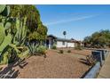View of a single-story home with desert landscaping, decorative cacti, and a quaint front entrance at 18035 N 29Th Dr, Phoenix, AZ 85053