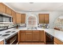 Well-lit kitchen featuring wood cabinetry, laminate countertops, and a large stainless steel sink at 19546 N 53Rd Ave, Glendale, AZ 85308