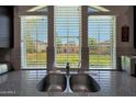 View from the kitchen sink showcases the backyard and neighborhood through bright, sunlit windows at 20545 W Terrace Ln, Buckeye, AZ 85396