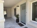 Inviting front porch with a sage door, decorative planter, and stone flooring at 2753 E Aster Dr, Phoenix, AZ 85032
