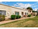 Exterior of a bright townhome with mature shrubs and partial view of the sidewalk at 3109 W Loma Ln, Phoenix, AZ 85051