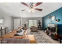 Spacious living room with a large leather sectional sofa, area rug, and a ceiling fan at 3109 W Loma Ln, Phoenix, AZ 85051
