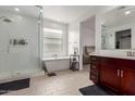 Bright bathroom with a glass-enclosed shower, soaking tub, and a stylish vanity with good natural light at 36922 N Camarillo Dr, San Tan Valley, AZ 85140