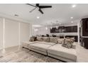 Spacious living room showcasing an oversized sectional sofa, open-concept layout, and modern ceiling fan at 36922 N Camarillo Dr, San Tan Valley, AZ 85140