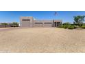 A detached three-car garage with desert landscaping on a sunny day at 38415 N 25Th Ave, Phoenix, AZ 85086