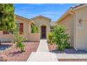 Inviting front entrance with a paved walkway, colorful bushes, and a charming, well-maintained exterior at 42485 W Abbey Rd, Maricopa, AZ 85138