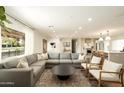 Spacious living room features modern gray sectional, natural light, and an open concept design at 547 W Orangewood Ave, Phoenix, AZ 85021