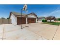 Spacious driveway featuring a basketball hoop with three-car garage and partial front exterior at 6232 N 88Th Ave, Glendale, AZ 85305