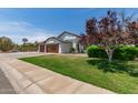 Beautiful home with a three-car garage, desert landscaping and well-maintained lawn at 6232 N 88Th Ave, Glendale, AZ 85305