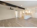 Spacious living room featuring modern flooring, a dark beam, and an open layout flowing into the bright kitchen at 6544 N 7Th Ave # 14, Phoenix, AZ 85013