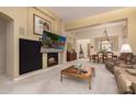 Open living area with fireplace, TV and a view into the dining room at 8324 E Cactus Wren Rd, Scottsdale, AZ 85250