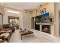 Inviting living room features a cozy fireplace, comfortable seating, and a sliding glass door at 8324 E Cactus Wren Rd, Scottsdale, AZ 85250