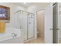 Bright bathroom featuring a glass shower, soaking tub and tile flooring at 8621 W Morten Ave, Glendale, AZ 85305