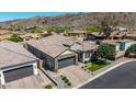 An aerial view of a home featuring a brick driveway, tile roof, well-manicured lawn, and desert landscaping at 9029 S 15Th St, Phoenix, AZ 85042