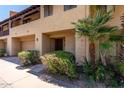 Welcoming condo with an attached garage, quaint front porch, and vibrant green landscaping at 10235 N 31St St # 2, Phoenix, AZ 85028