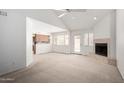 Bright living room featuring vaulted ceilings, fireplace, access to the back patio, and a peek into the kitchen at 10235 N 31St St # 2, Phoenix, AZ 85028