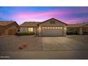 Charming single-story home featuring a two-car garage and desert landscaping set against a pink sunset sky at 10617 W Ross Ave, Peoria, AZ 85382